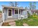 Charming home with a welcoming front porch, complemented by colorful shutters, flowers, and a yellow bench at 3278 S Lafayette St, Englewood, CO 80113