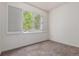 Bedroom featuring neutral carpet, white walls and a bright window with shutters at 8427 S Hoyt Way # 107, Littleton, CO 80128