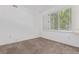 Well-lit bedroom featuring neutral carpet, bright window with shutters, and white walls at 8427 S Hoyt Way # 107, Littleton, CO 80128