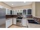 Well-lit kitchen with stainless steel appliances and brown backsplash at 8427 S Hoyt Way # 107, Littleton, CO 80128