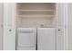 Modern laundry closet with washer and dryer connections, plus shelving for storage at 8427 S Hoyt Way # 107, Littleton, CO 80128