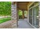 Covered outdoor patio featuring stone columns and a view of lush greenery at 8427 S Hoyt Way # 107, Littleton, CO 80128