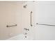 Bright bathroom features a tub and shower combo with tile surround and grab bars for accessibility at 4675 S Yosemite St # 205, Denver, CO 80237