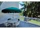Charming deck with table, chairs, and umbrella is surrounded by lush trees, offering a peaceful outdoor space for relaxation at 4675 S Yosemite St # 205, Denver, CO 80237