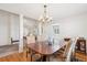 Open concept dining room with a chandelier and large table next to an entry and living space at 4675 S Yosemite St # 205, Denver, CO 80237