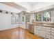 Bright kitchen nook with stainless steel dishwasher, white cabinets, and wooden floors offers a cozy eating area at 4675 S Yosemite St # 205, Denver, CO 80237