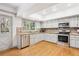 Functional kitchen featuring white cabinets, stainless steel appliances, and hardwood floors for efficient meal preparation at 4675 S Yosemite St # 205, Denver, CO 80237
