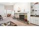 Open-concept living room with stone fireplace, built-in bar, and views into dining room provide elegant flow and easy entertaining at 4675 S Yosemite St # 205, Denver, CO 80237