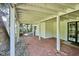 Covered patio featuring red brick pavers, white support columns, and access to the backyard at 4675 S Yosemite St # 205, Denver, CO 80237