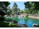 Scenic pond with a fountain, surrounded by lush greenery and rocks, creating a tranquil setting at 4675 S Yosemite St # 205, Denver, CO 80237