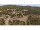 Expansive aerial view of a forested landscape with scattered homes and winding roads, highlighting the serene mountain community at 27888 Richmond Hill Rd, Conifer, CO 80433