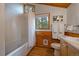Cozy bathroom with a bathtub, vanity, and views of the forest through the window at 27888 Richmond Hill Rd, Conifer, CO 80433
