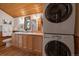 Bathroom with double vanity, storage, views of the forest, and a stacked washer and dryer at 27888 Richmond Hill Rd, Conifer, CO 80433