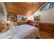 Cozy bedroom featuring vaulted wood ceilings, paneling, built-ins, and natural light from the windows at 27888 Richmond Hill Rd, Conifer, CO 80433