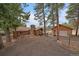 Charming log cabin-style home with a stone chimney and detached garage surrounded by mature trees at 27888 Richmond Hill Rd, Conifer, CO 80433