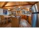 Spacious kitchen features stainless steel appliances, a kitchen island, and an adjacent dining area with forest views at 27888 Richmond Hill Rd, Conifer, CO 80433