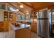 Well-lit kitchen featuring stainless steel refrigerator, center island, and wood cabinets with ample storage at 27888 Richmond Hill Rd, Conifer, CO 80433