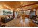 Spacious living room with wood paneling, hardwood floors, and a combined kitchen and dining area at 27888 Richmond Hill Rd, Conifer, CO 80433