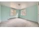 The bright bedroom features light blue walls, two windows, and carpeted floors creating a peaceful and airy atmosphere at 31168 Witteman Rd, Conifer, CO 80433