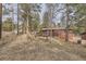 Exterior view of house with deck and wooded lot at 31168 Witteman Rd, Conifer, CO 80433