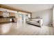 Bright living room with a tan couch, light wood floors, and an open layout flowing into the kitchen space at 31168 Witteman Rd, Conifer, CO 80433