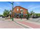 Corner building with brick facade, large windows, outdoor seating, and vintage-style streetlights at 7931 W 55Th Ave # 105, Arvada, CO 80002