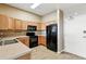 Efficient kitchen design with wooden cabinets, black appliances, and tile flooring, perfect for cooking at 7931 W 55Th Ave # 105, Arvada, CO 80002