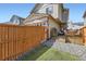 Fenced backyard with artificial grass, gravel, and a covered patio area at 11769 Lovegrass Dr, Parker, CO 80138