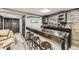 Basement bar boasts wood counters, stooled seating, rustic shelving and decorative lighting at 11769 Lovegrass Dr, Parker, CO 80138