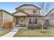 Charming two-story home featuring stone accents, manicured lawn, and inviting front porch at 11769 Lovegrass Dr, Parker, CO 80138