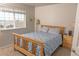 Bright bedroom showcasing a wooden bed frame, ample natural light, and a serene atmosphere at 3725 S Nepal St, Aurora, CO 80013