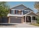 Charming two-story home with a three car garage, covered porch, gray siding and brick accents at 3725 S Nepal St, Aurora, CO 80013
