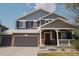 Charming two-story home with a three car garage, covered porch, gray siding and brick accents at 3725 S Nepal St, Aurora, CO 80013