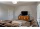 Spacious living room featuring an entertainment center, sofa, and plush ottoman at 3725 S Nepal St, Aurora, CO 80013