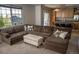 Open living room with a large sectional sofa and plush ottoman next to a window at 3725 S Nepal St, Aurora, CO 80013
