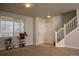 Bright living room with natural light, fresh paint and adjacent stairs with white banister at 3725 S Nepal St, Aurora, CO 80013