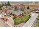 Expansive aerial view of brick home featuring mature trees, landscaping and detached garage at 1324 State Highway 66, Longmont, CO 80504