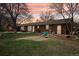 Large backyard with patio area, mature trees, and playset, ideal for outdoor living at 1324 State Highway 66, Longmont, CO 80504