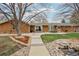 Large backyard featuring a stone patio, pond, mature trees and lush landscaping at 1324 State Highway 66, Longmont, CO 80504