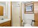 Bright bathroom featuring a shower, toilet, sink, and window with wood trim at 1324 State Highway 66, Longmont, CO 80504