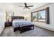 Bright bedroom features a ceiling fan, windows, and a bed with a striped blanket, creating a cozy and inviting space at 1324 State Highway 66, Longmont, CO 80504