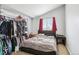 Bedroom with a closet rack full of clothes and a window with red curtains at 1324 State Highway 66, Longmont, CO 80504