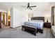 Bright bedroom features a ceiling fan, windows, and a bed with a striped blanket, creating a cozy and inviting space at 1324 State Highway 66, Longmont, CO 80504