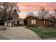 Inviting single-story brick home featuring a circular driveway and professional landscaping at 1324 State Highway 66, Longmont, CO 80504