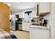 Well-lit kitchen with white cabinets, stainless steel appliances, and modern countertops at 1324 State Highway 66, Longmont, CO 80504