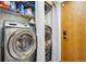 Modern laundry room with washer, dryer, and shelving for storage, complete with wooden door at 1324 State Highway 66, Longmont, CO 80504