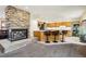 Open-concept living area with stone fireplace, breakfast bar, and adjacent kitchen appliances at 1324 State Highway 66, Longmont, CO 80504