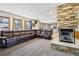 Living area featuring a stone fireplace, plush carpet, and a comfortable leather sectional couch at 1324 State Highway 66, Longmont, CO 80504