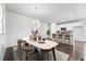 Open-concept dining area leading into a modern kitchen with bar stool seating and elegant light fixtures at 3548 Swabuck Pl, Castle Rock, CO 80109
