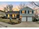 Charming two-story home featuring a two-car garage, front porch, and landscaped front yard during a colorful sunset at 6918 E Easter Pl, Centennial, CO 80112